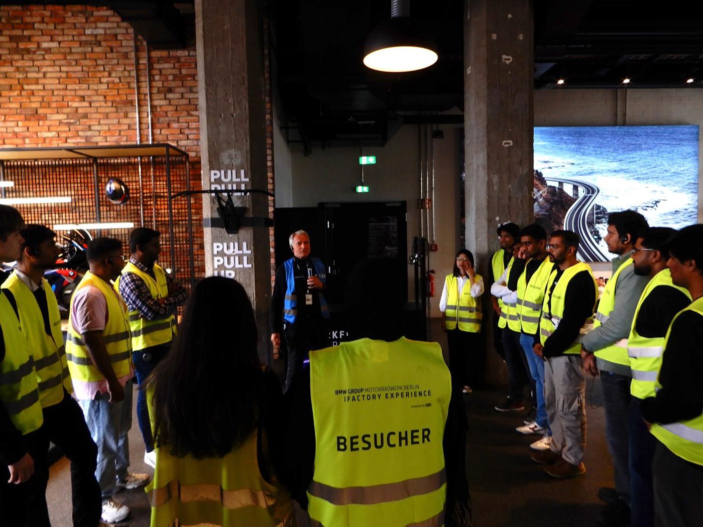 Guide addressing students inside BMW Motorrad Berlin