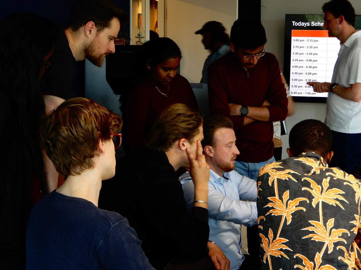 Students and hosts looking at a screen during a company visit