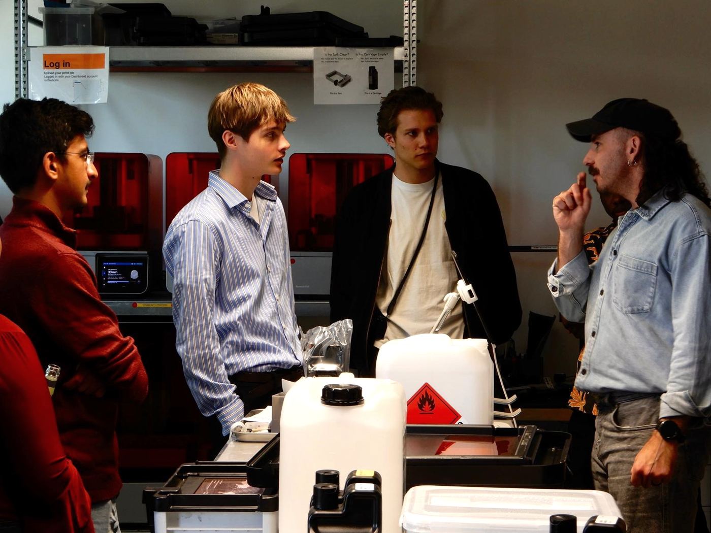 Students talking with a Formlabs employee next to 3D-printing equipment